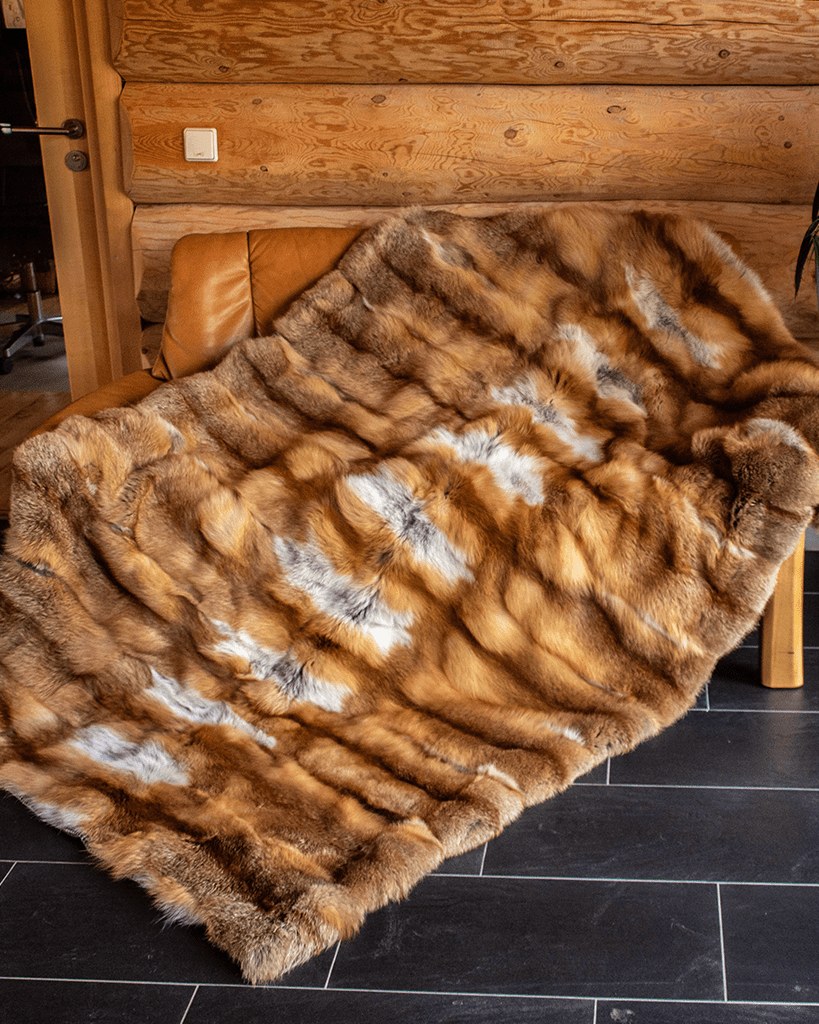 Klassische Rotfuchs-Decke über einer Holzbank, gestreifte Fellbahnen