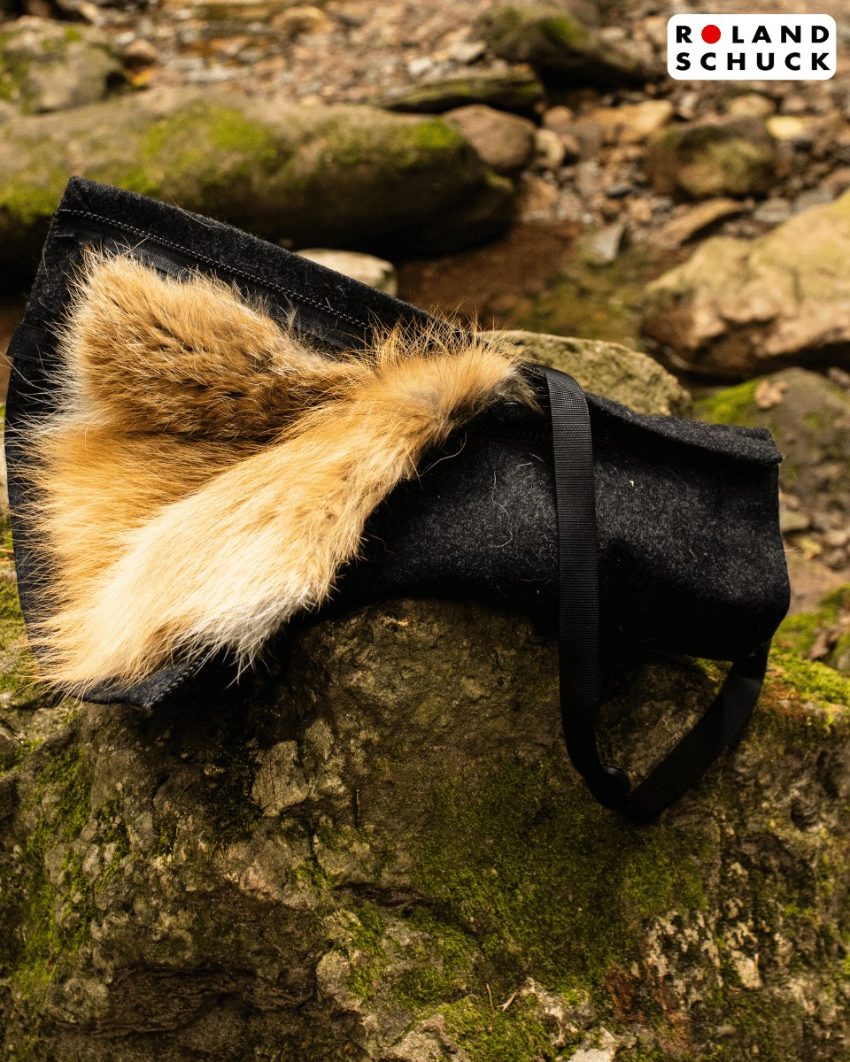 Rotfuchs Loden-Muff auf moosbewachsenem Fels im Wald